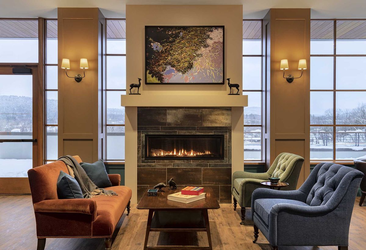 A cozy living room features a warm fireplace, comfortable seating, and tasteful decor.