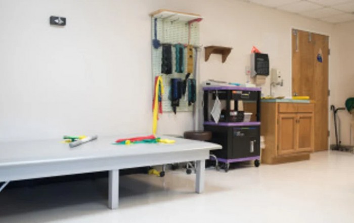 A physical therapy room equipped with various exercise and rehabilitation tools.