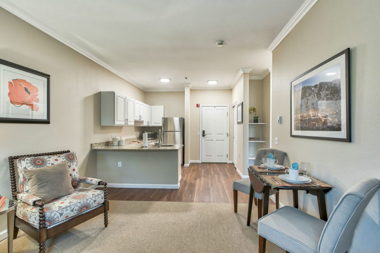 A modern apartment interior featuring a compact kitchen, a cozy living area, and a small dining space.