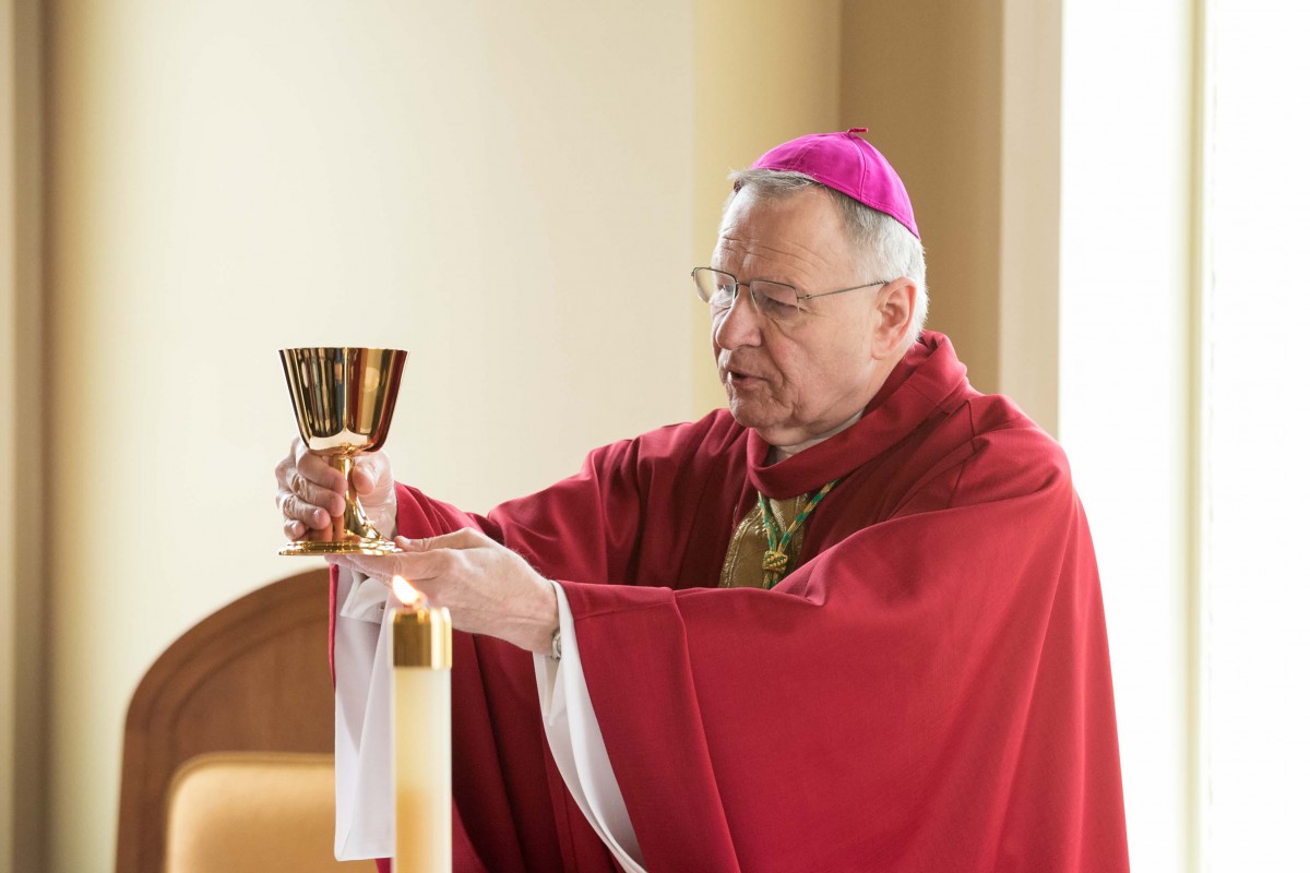 A bishop dressed in liturgical vestments holding a chalice during a religious ceremony.