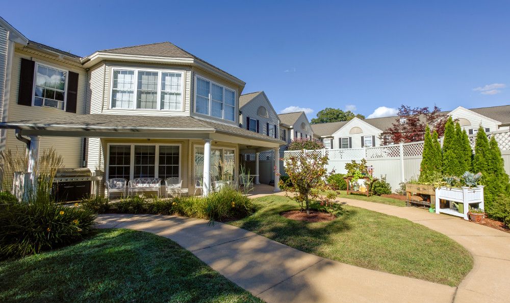 A charming residential house with a well-maintained garden and clear blue skies.
