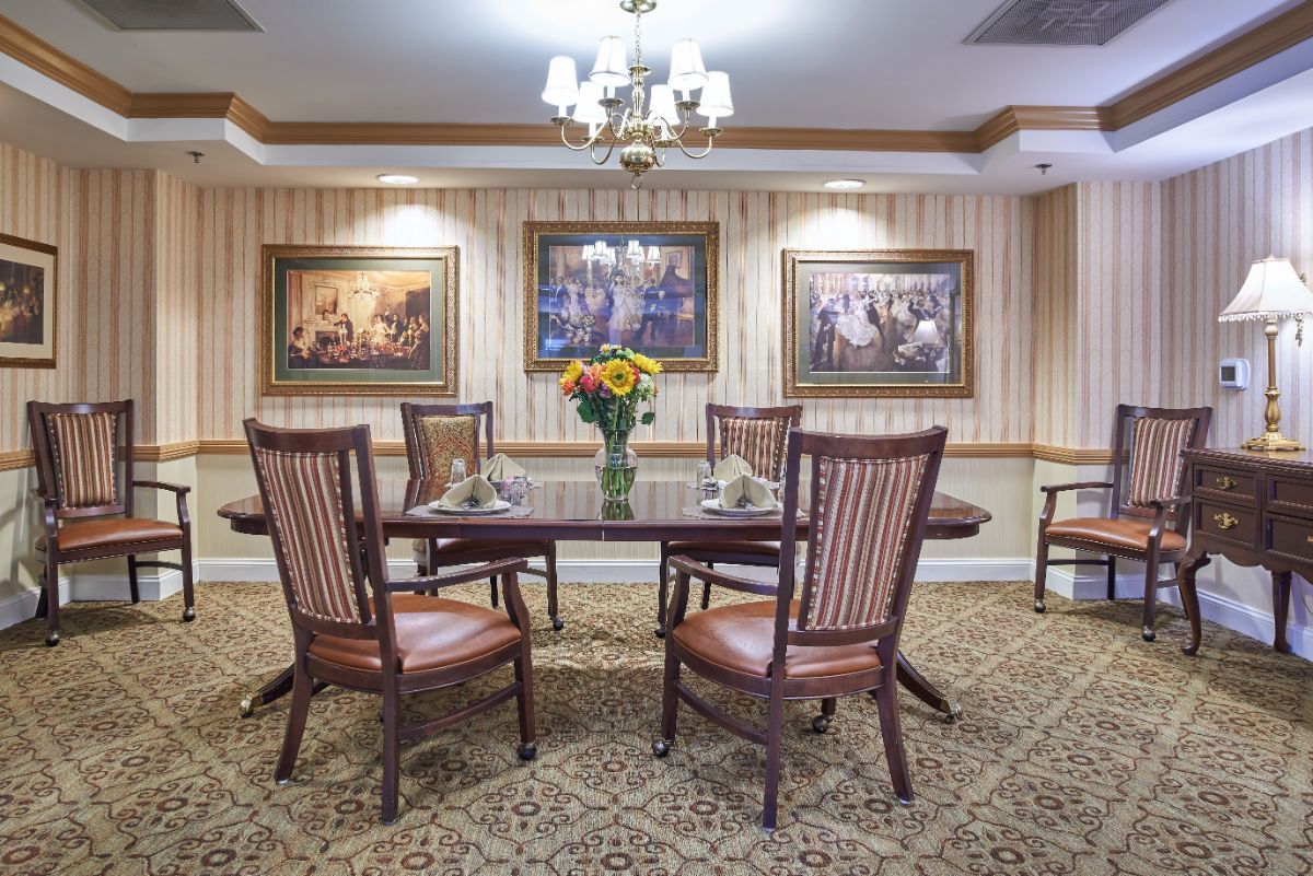 A well-furnished dining room with a table, chairs, and decorative artwork on the walls.