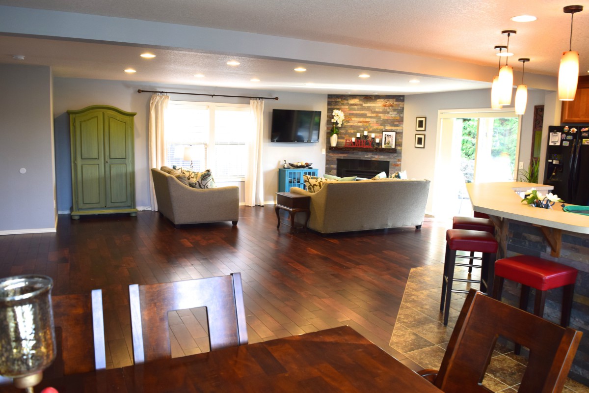 Spacious modern living room with hardwood floors, cozy couches, and a fireplace.