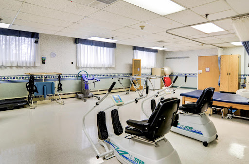 A spacious rehabilitation therapy room equipped with various fitness equipment for patient exercises.