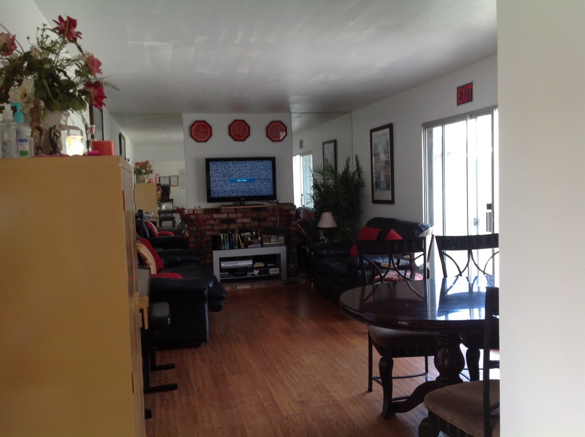A cozy living room with a television and sofa set, complemented by a dining area in the foreground.