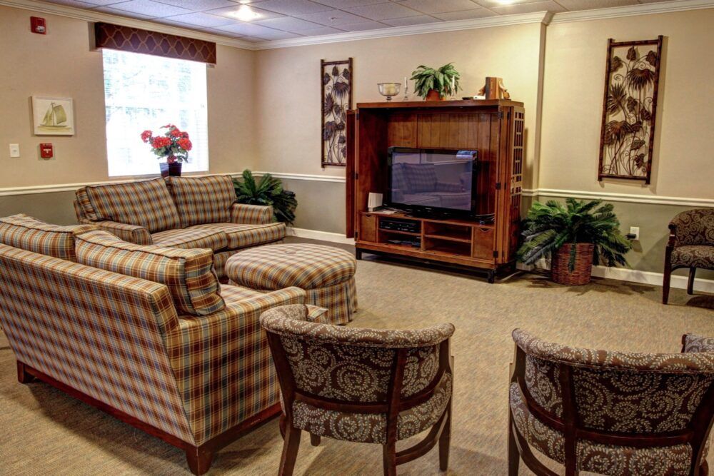 A cozy living room with patterned furniture and a television.