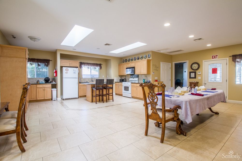 Spacious modern kitchen with an open dining area, featuring wooden cabinets and a tiled floor.