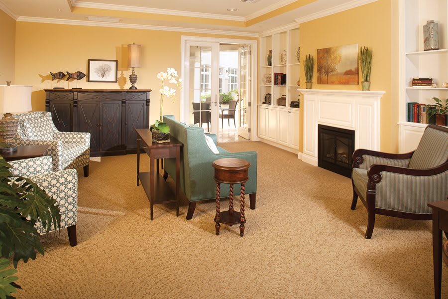 A cozy living room with warm yellow walls, a fireplace, and comfortable seating.