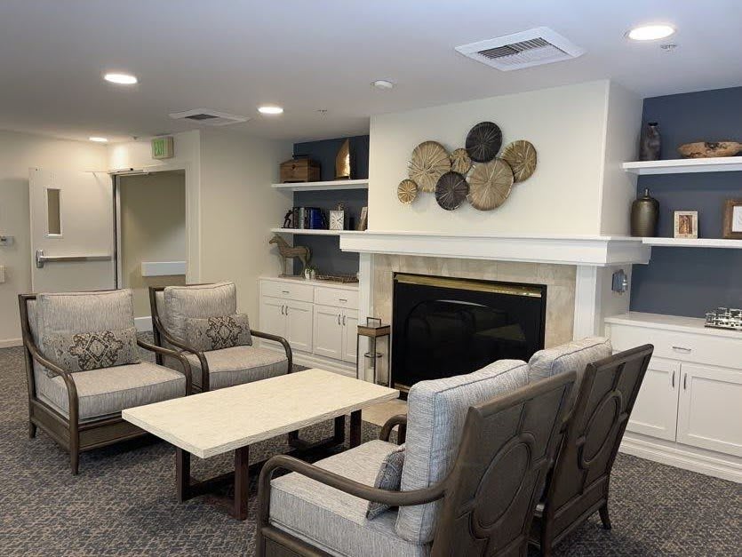A cozy living room with comfortable seating and a decorative fireplace.