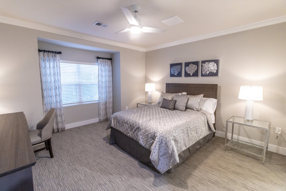 A modern and cozy bedroom with a neatly made bed, soft lighting, and neutral decor.