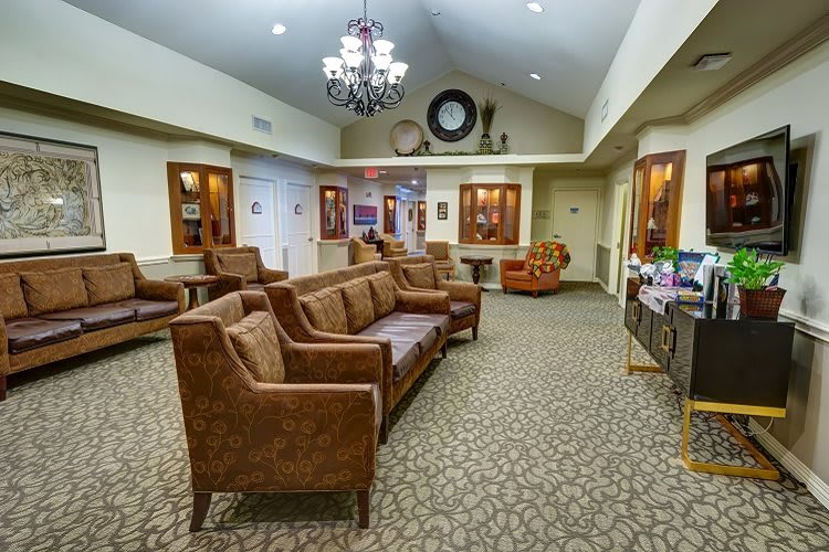 A cozy lobby interior featuring comfortable sofas, a chandelier, and warm decor.