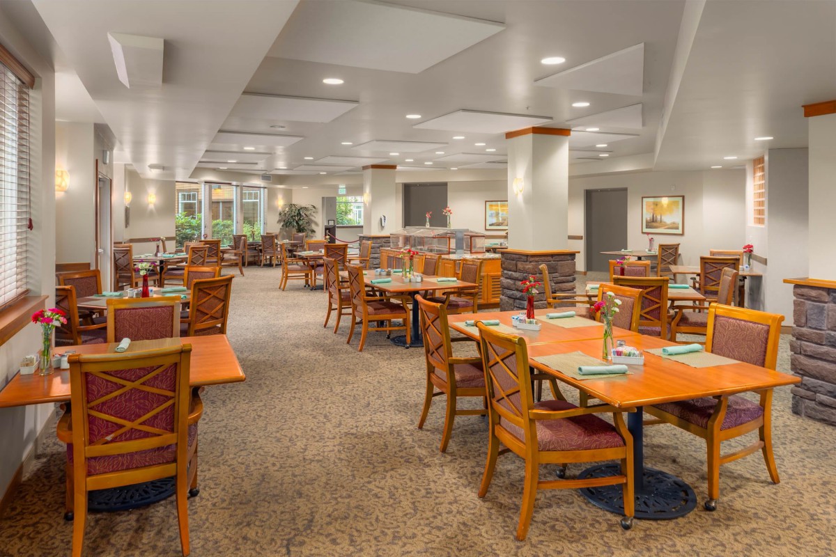 An empty restaurant dining area with neatly arranged tables and chairs.