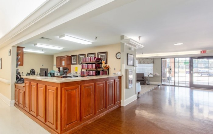 A spacious reception area with a wooden desk and cozy waiting space.