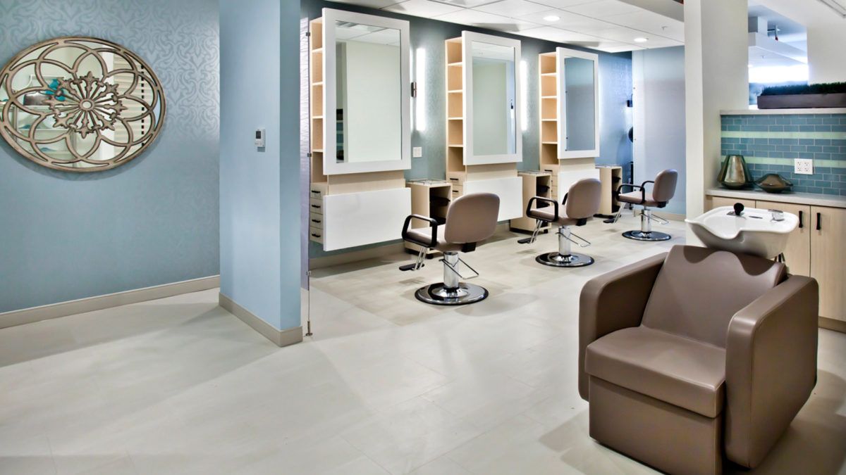 A modern hair salon interior with styling stations and comfortable chairs.
