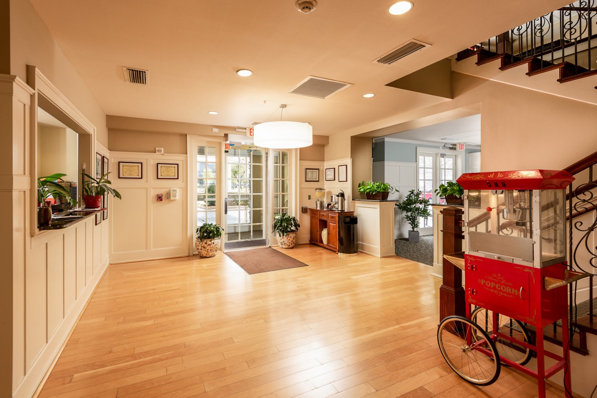 A cozy interior entryway featuring a wooden floor and a popcorn machine.