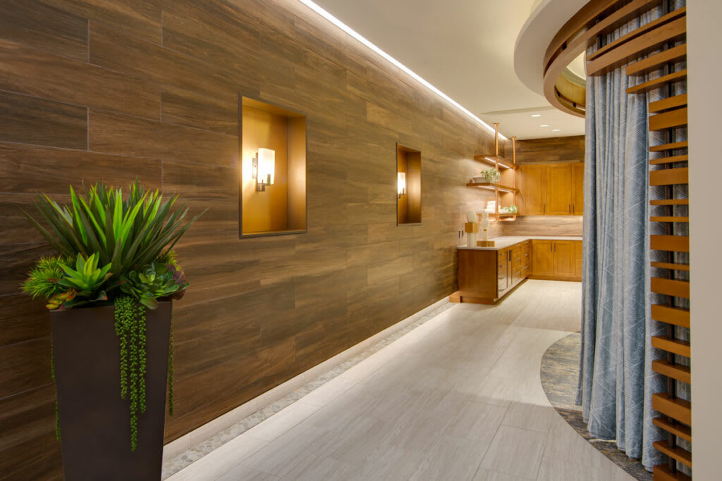 A modern hallway featuring wood paneling and ambient lighting.