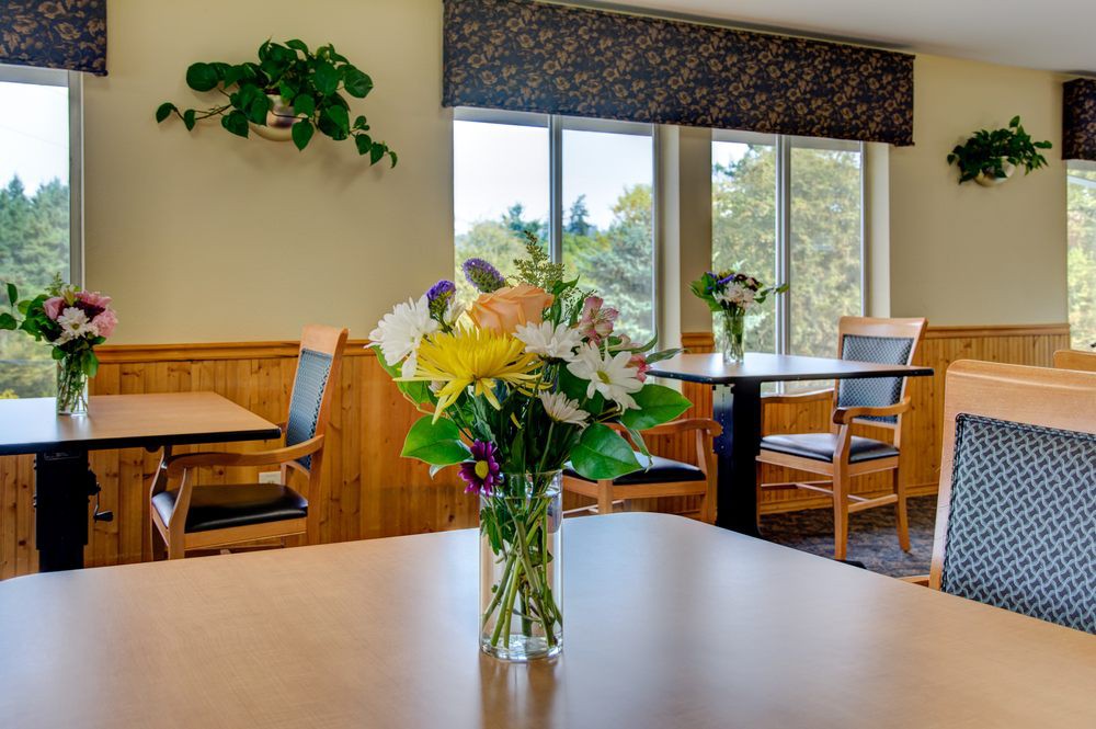 A cozy dining room with a vase of colorful flowers on the table.
