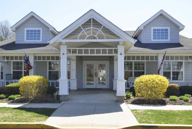 A charming residential house with a symmetrical porch and well-maintained landscaping.
