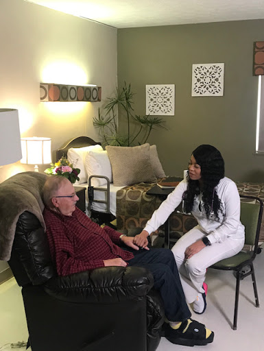 A caregiver gently interacts with an elderly gentleman in a cozy indoor setting, highlighting the importance of companionship and support.