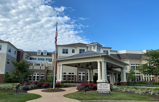 A welcoming community center featuring beautiful landscaping and an American flag.