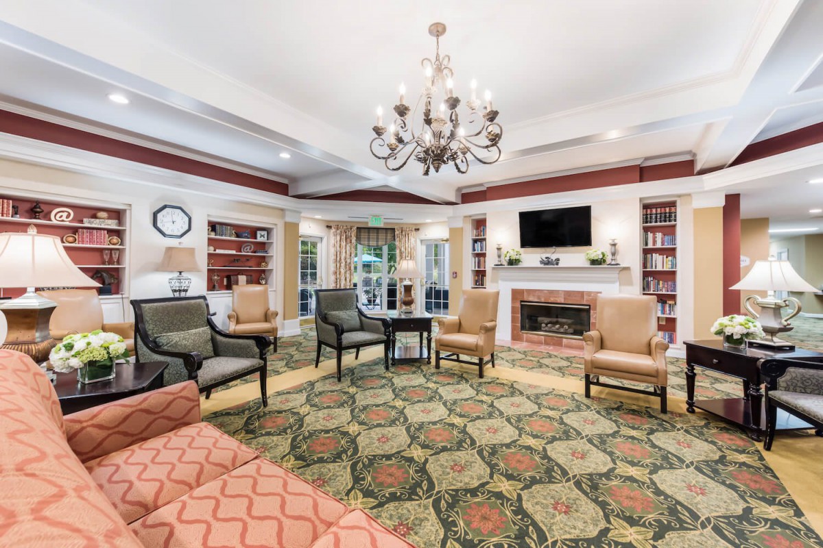 Elegant living room with a chandelier, bookshelves, and fireplace.
