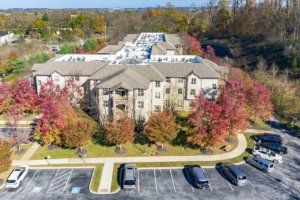 Aerial view of a residential apartment complex surrounded by colorful autumn trees.