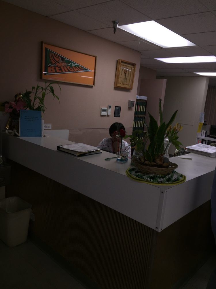 A receptionist sitting at a desk in an office environment.