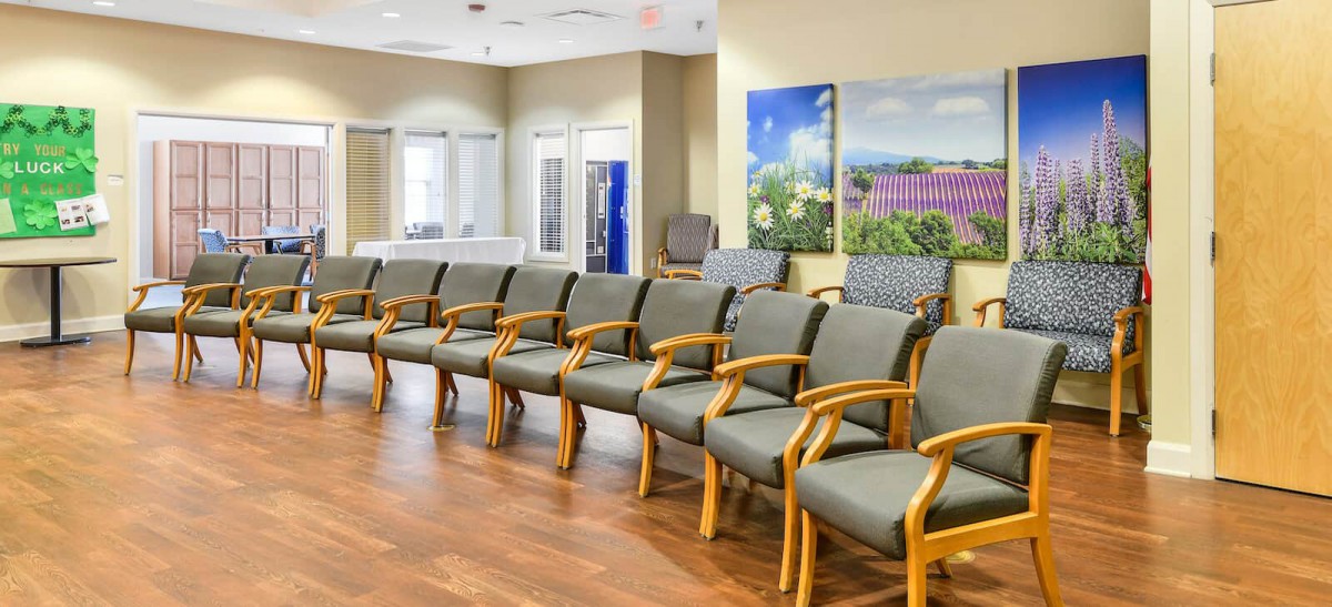 A spacious waiting room with multiple chairs lined up along the wall.