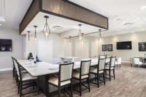 A modern dining area with a kitchen island and stylish lighting fixtures.