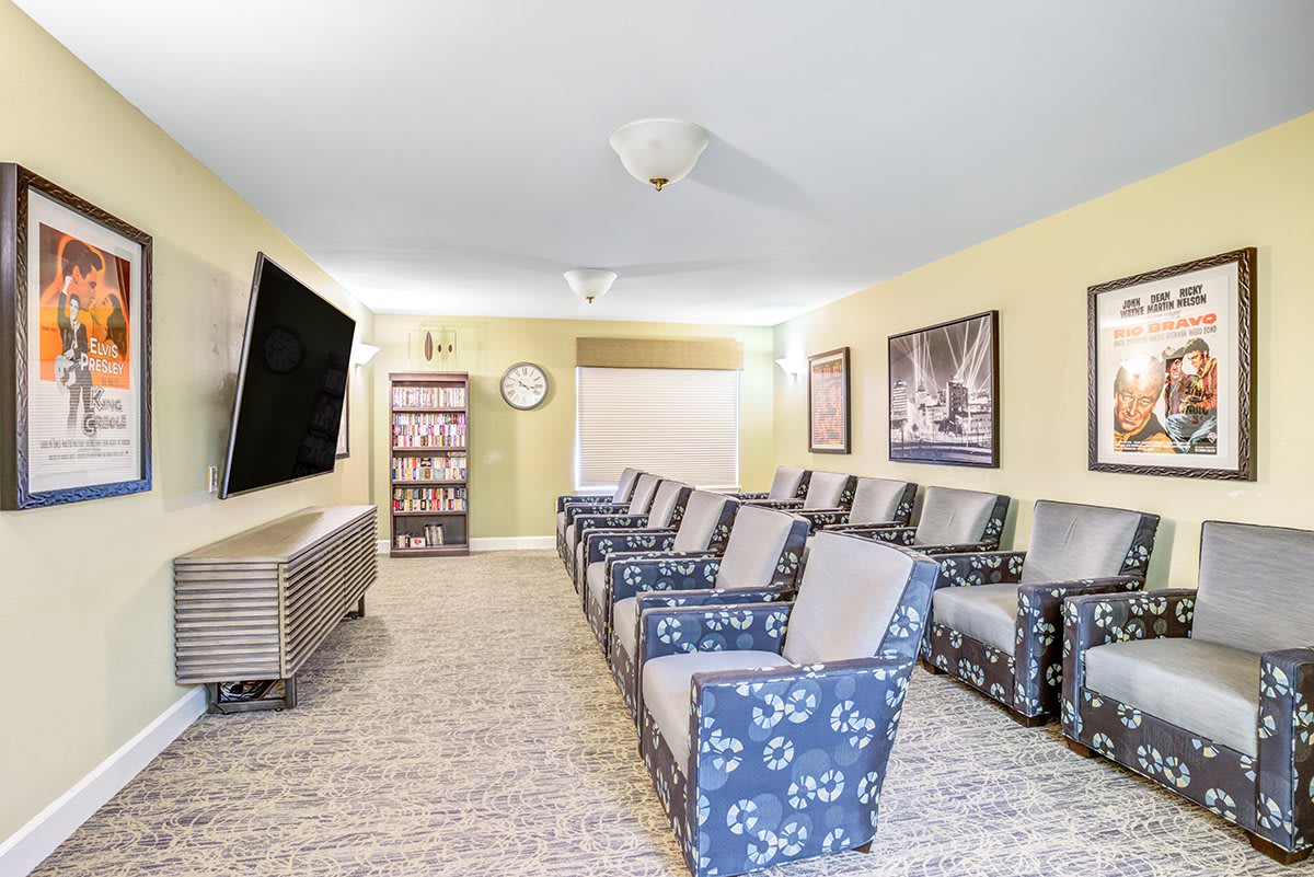 A cozy theater room with comfortable seating and a large television screen.