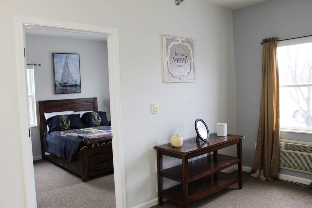 A cozy bedroom with nautical-themed decor and simple furnishings.