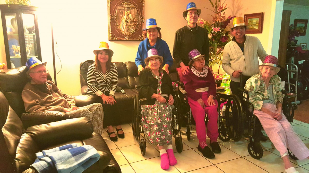 A group of people gathered indoors, wearing colorful hats, celebrating together.