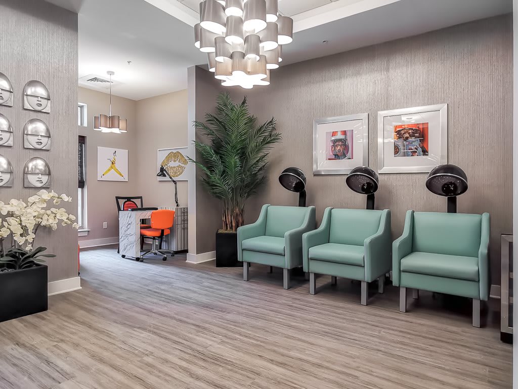 A modern hair salon waiting area with stylish chairs and artwork.