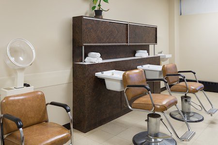 A modern hair salon interior with chairs and sinks for hair washing.