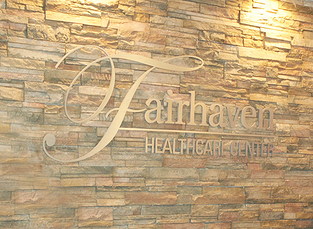 Interior signage for Fairhaven Healthcare, featuring a stylish design on a stone wall.