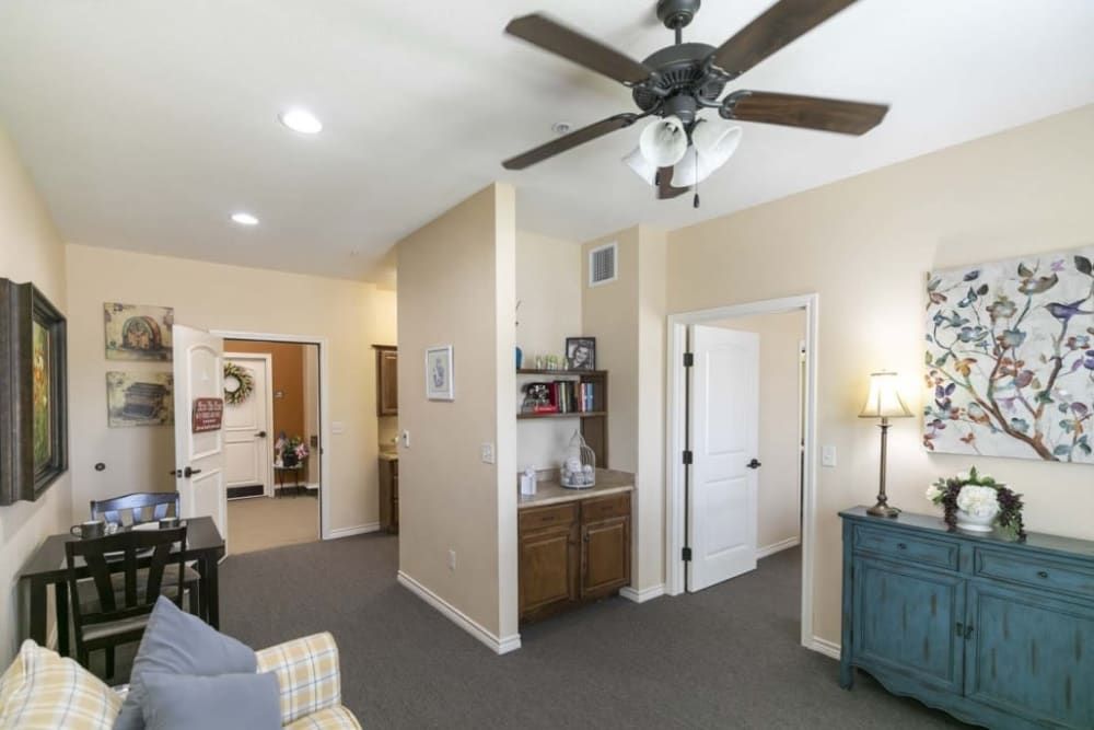 A cozy living room with a ceiling fan, sofa, and decorative elements.