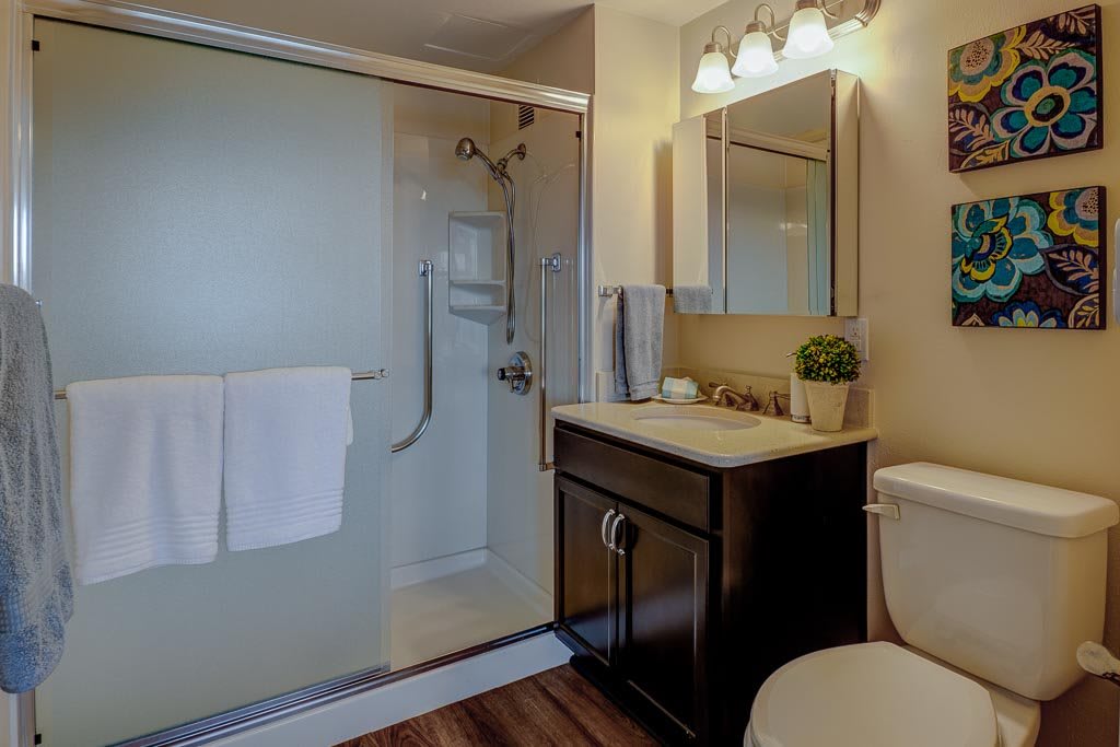 A modern bathroom with a glass-enclosed shower, elegant vanity, and cozy lighting.