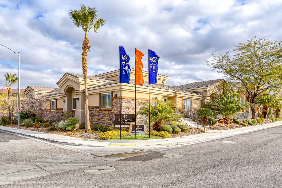 A residential home with flags in the front yard under a cloudy sky.