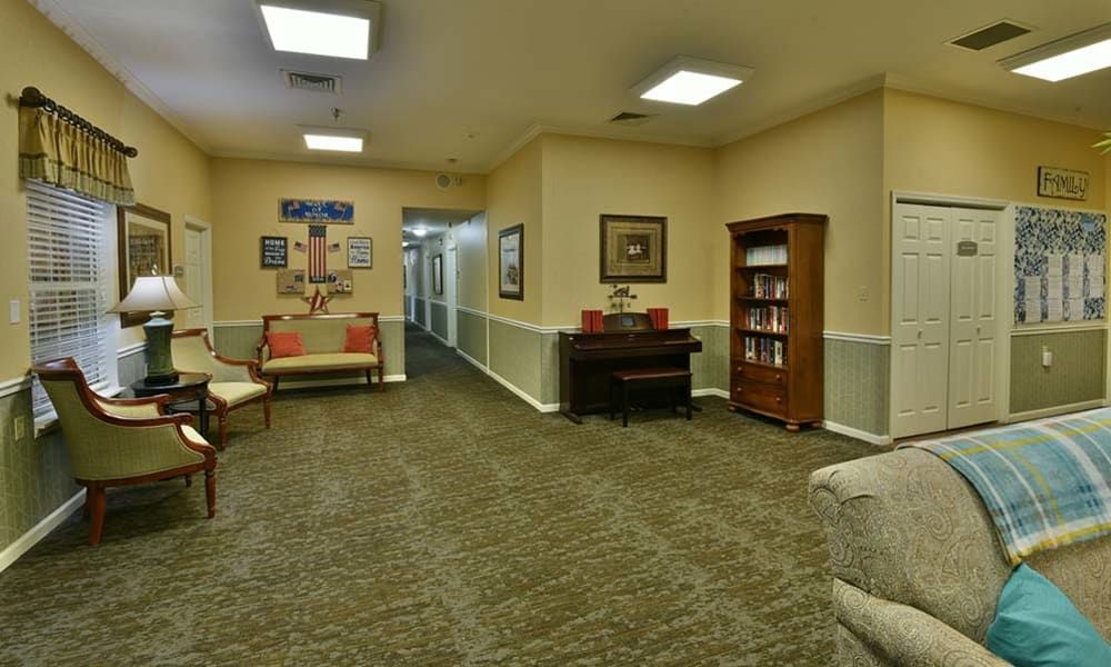 Cozy lobby with hallway, featuring seating and a bookshelf.