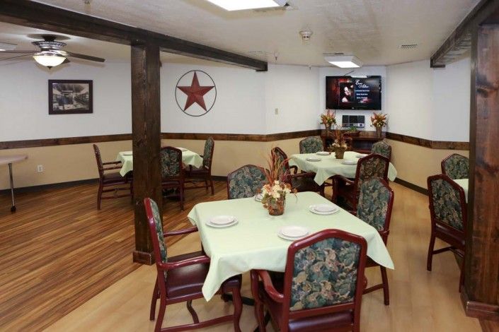 An interior view of a dining area with tables and chairs, featuring a star decoration on the wall.