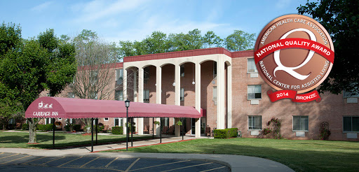 A modern residential building featuring elegant columns and a protective canopy at the entrance.
