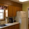 A cozy kitchen with wooden cabinets, a refrigerator, and a sink.