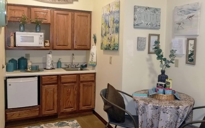 A cozy kitchen and dining area with wooden cabinets and a small table.