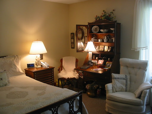 A cozy and inviting bedroom setting featuring warm lighting, comfortable furniture, and decorative shelves.