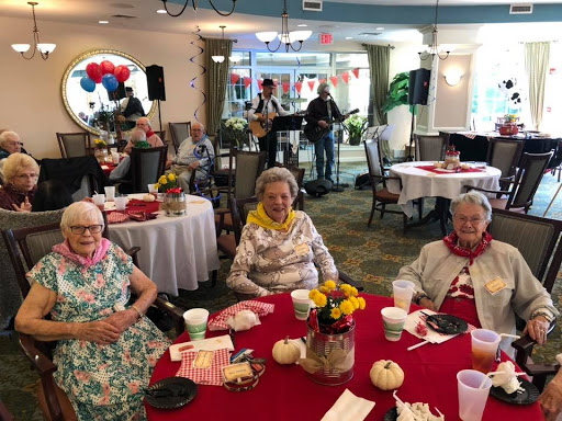 A joyful gathering of elderly individuals enjoying a musical performance at a community celebration.