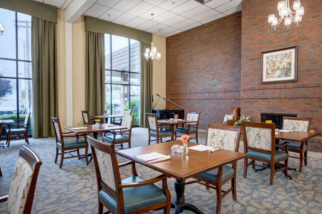 A well-lit dining area with elegant furniture and large windows offering a comfortable setting.