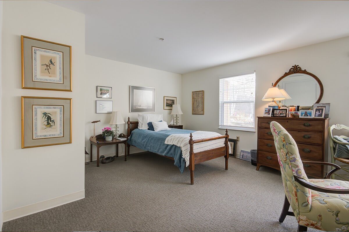 A cozy bedroom with a single bed, decorated in neutral tones and featuring elegant furniture.