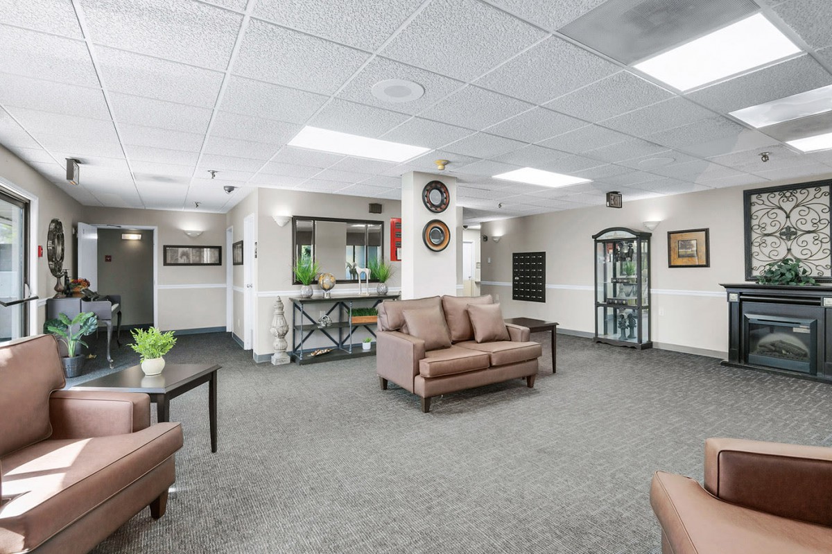 A spacious and well-decorated lobby area with comfortable seating, artwork on the walls, and decorative plants.
