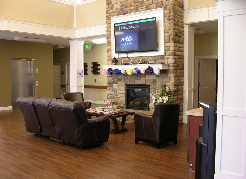 A cozy lounge area featuring comfortable seating, a fireplace, and a mounted television.