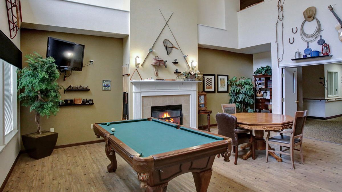 A cozy recreation area featuring a billiards table and a fireplace.